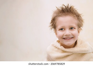 Close-up Portrait Of Joyful Cute Caucasian Little Boy Not Looking At Camera, Toothy Smiling, Wrapped In Orange Towel With Wet Hair. Horizontal Shot With Copy Space. Children Hygien Concept