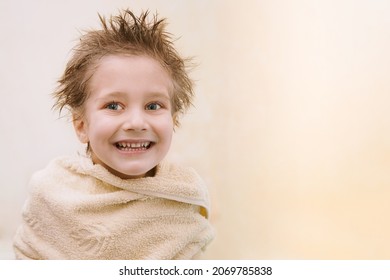 Close-up Portrait Of Joyful Cute Caucasian Little Boy Not Looking At Camera, Toothy Smiling, Wrapped In Orange Towel With Wet Hair. Horizontal Shot With Copy Space. Children Hygien Concept