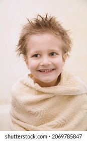 Close-up Portrait Of Joyful Cute Caucasian Little Boy Not Looking At Camera, Toothy Smiling, Wrapped In Orange Towel With Wet Hair. Vertical Headshot. Easy Children Washing Concept