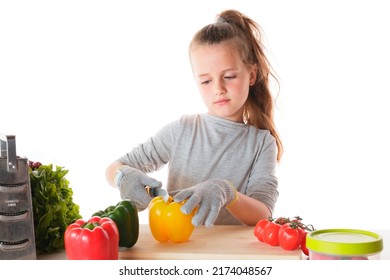 A Closeup Portrait Of A Kid Cutting Vegetables With A Knife Wearing Safety Gloves