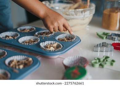 Close-up portrait of kid's hands making and decorating cupcakes with chocolate sprinkles at home kitchen. Family, cooking and people concept - Powered by Shutterstock