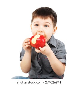Close-up portrait of a little boy eating red apple isolated on white background