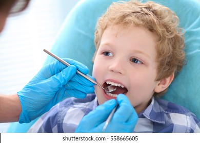 Close-up Portrait Of Little Boy Opening His Mouth Wide During Inspection Of Oral Cavity By Dentist.