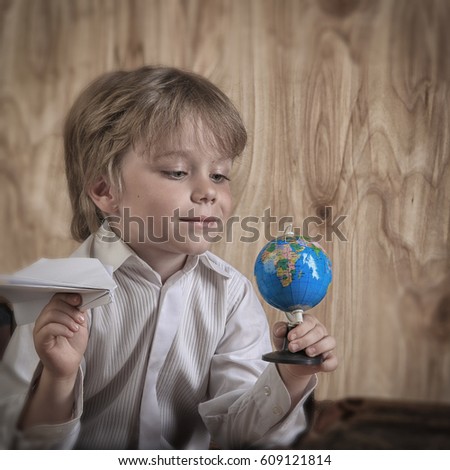 closeup portrait little boy traveler on a wooden background studio