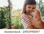 Close-up portrait of a little girl hugging a puppy. A cute small kid is playing with a dog. A sweet child is happy with her pet. A lovely preschool girl takes care of the labrador