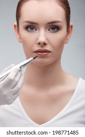 closeup portrait of lovely young woman getting permanent makeup on her lips
