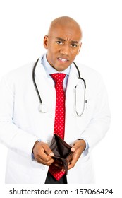 Close-up Portrait Of A Male Doctor Looking Shocked, Troubled And Puzzled By His Empty Wallet Isolated On A White Background. Health Care Reform, Medicare And Medicaid Reimbursement, Obamacare Concept.