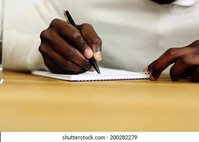 Closeup Portrait Of A Male Hand Writing On A Paper