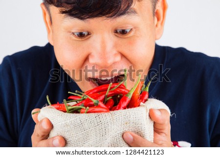 Close-up Portrait of a man eating chili,Asian men and chili,man with chili in his hand