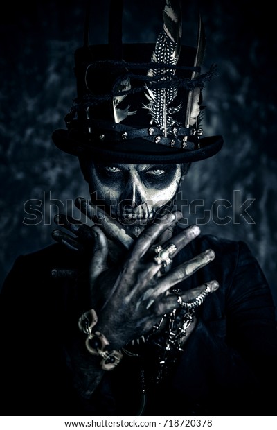 Close-up portrait of a man with a\
skull makeup dressed in a tail-coat and a top-hat. Baron Saturday.\
Baron Samedi. Dia de los muertos. Day of The Dead.\
Halloween.