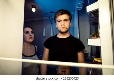 Closeup Portrait Of Man And Woman Looking In Empty Refrigerator At Night