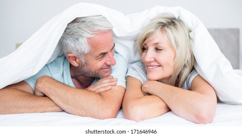 Close-up Portrait Of A Mature Couple Lying In Bed At Home