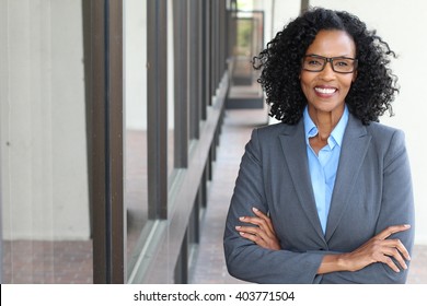 Closeup portrait, mature professional, beautiful confident woman wearing a power suit, friendly personality, smiling isolated indoors office background. Positive human emotions - Shutterstock ID 403771504