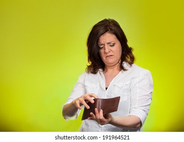 Closeup Portrait, Mature, Sad, Middle Aged, Surprised, Unhappy, Puzzled Woman, Shocked, Holding, Showing Empty Wallet, Isolated Green Background. Negative Human Emotions, Facial Expressions, Reaction