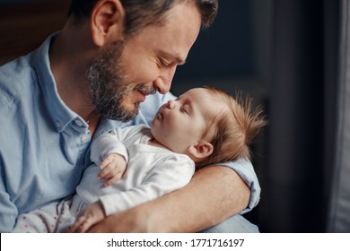 Closeup Portrait Of Middle Age Bearded Caucasian Father Hugging And Kissing Newborn Baby. Male Man Parent Holding Child. Authentic Lifestyle Touching Tender Moment. Single Dad Family Life Concept. 