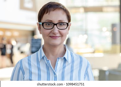 Closeup portrait of middle aged woman wearing glasses. Professional headshot of businesswoman, teacher, manager. Blurred office background. - Shutterstock ID 1098451751