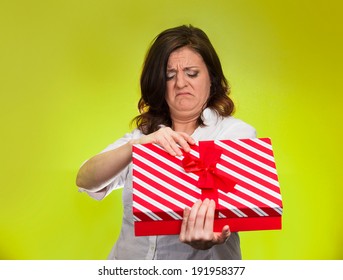 Closeup Portrait Middle Aged Woman Holding, Opening Gift Box, Displeased, Disgusted, What She Received, Isolated Green Background. Negative Human Emotion, Facial Expression, Feeling Attitude Reaction