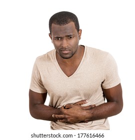 Closeup Portrait Of Miserable, Upset, Ill, Unhealthy, Young Man, Doubling Over In Stomach Pain, Looking Very Sick Unwell Isolated On White Background. Facial Expressions Emotion Reaction Health Issues