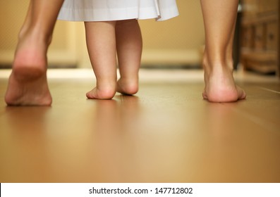 Closeup Portrait Of A Mother Teaching Baby To Walk Indoors