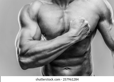 Closeup Portrait Of A Muscular Man Showing His Biceps. HDR Monochrome.