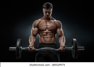 Closeup portrait of a muscular man workout with barbell at gym. Brutal bodybuilder athletic man with six pack, perfect abs, shoulders, biceps, triceps and chest. Deadlift barbells workout. 