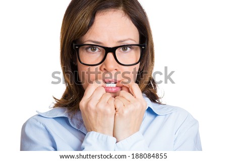 Closeup portrait nervous nerd, woman in black glasses, biting fingernails craving something, anxious, isolated white background. Negative human emotion, facial expression, feeling reaction