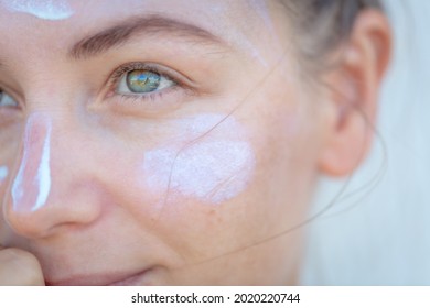Closeup Portrait of a Nice Blond Female with Cream on a Face. Face Part. Using Spf. Spa Health Care and Beauty Treatment Concept.
