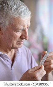 Close-up Portrait Of An Older Man Taking A  Medicine