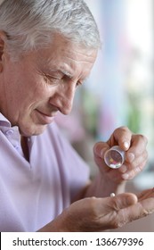 Close-up Portrait Of An Older Man Taking A  Medicine