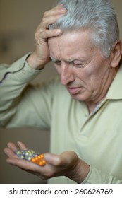 Close-up Portrait Of An Older Man Taking A Medicine