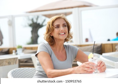 Closeup Portrait Of An Older Woman Relaxing Outdoors With A Glass Of Water