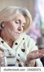 Close-up Portrait Of An Older Woman Taking A  Medicine