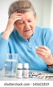 Close-up Portrait Of An Older Woman Taking A Medicine