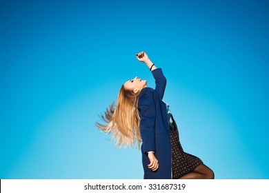 close-up portrait on a background of blue sky autumn lifestyle of young beautiful girl with stylish blonde with long hair blonde outdoors in coat and scarf  is laughing and happy - Powered by Shutterstock