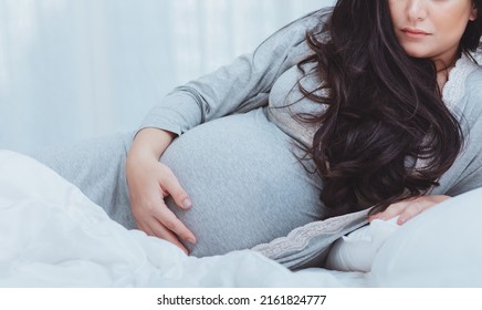 Closeup Portrait On A Pregnant Woman With Gorgeous Dark Hair. Spending Time At Home. Happy Healthy Pregnancy. Family Love Concept