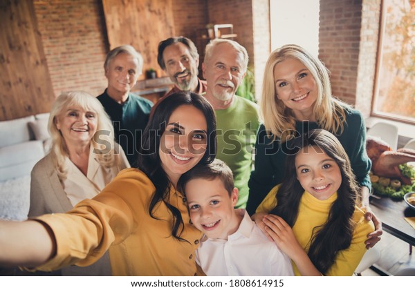 Closeup portrait photo of full big family\
gathering eight people make selfie cuddle embrace wait pray thank\
god have good autumn time make wish generation in home evening\
living room indoors