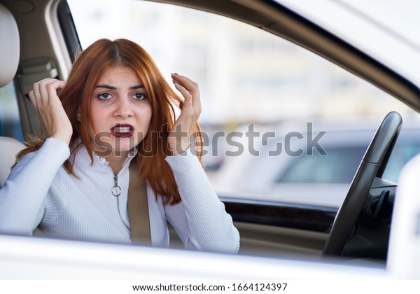 Closeup portrait of pissed off displeased angry
aggressive woman driving a car shouting at someone. Negative human
expression consept.