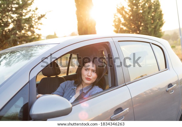 Closeup portrait of pissed off displeased angry\
aggressive woman driving a car shouting at someone with hand up.\
Negative human expression\
consept.
