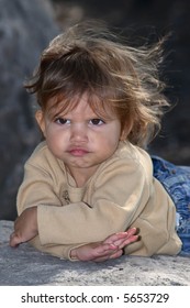 A Close-up Portrait Pouting Toddler Poses In Protest