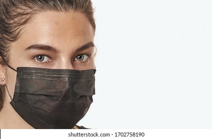 A close-up portrait of a pretty female with stethoscope wearing a surgical mask isolated on a white background. - Shutterstock ID 1702758190
