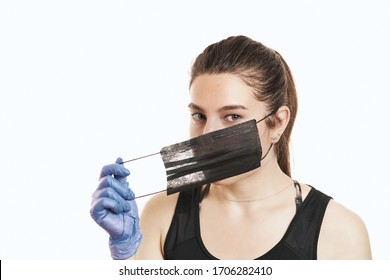 A close-up portrait of a pretty female wearing a surgical mask isolated on a white background - Shutterstock ID 1706282410