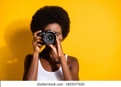 Close-up portrait of pretty wavy-haired brunette girl using digicam taking pictures snap isolated over bright yellow color background