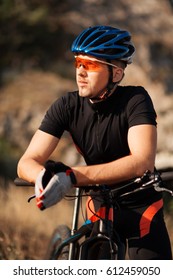 Closeup Portrait Of Professional Cyclist With His Bicycle In The Countryside