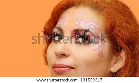 Closeup portrait of the red haired girl with body art painting