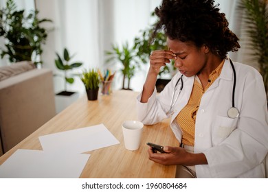 Closeup Portrait Sad Unhappy Health Care Professional With Headache, Stressed, Sleepy Holding A Phone. Nurse Doctor With Migraine Overworked Overstressed.