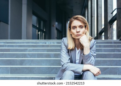 Close-up portrait of sad upset business woman sitting tired on stairs of office building - Powered by Shutterstock