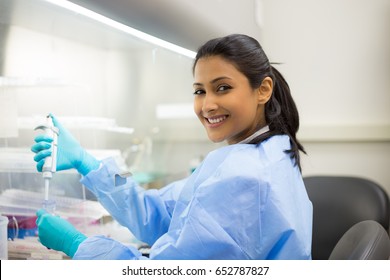 Closeup portrait, scientist pipetting from 50 mL conical tube with blue liquid solution, performing laboratory experiments, isolated lab . Forensics, genetics, microbiology, biochemistry