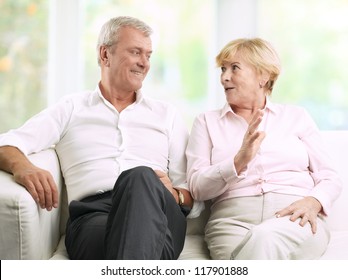 Close-up portrait of senior couple sitting on couch and talking స్టాక్ ఫోటో