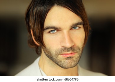 Closeup Portrait Of A Serious Good Looking Young Man With Long Hair