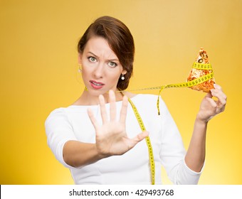 Closeup Portrait Serious Woman Saying No To Fatty Pizza With Measuring Tape Around, Trying To Withstand, Resist Temptation To Eat It Isolated On Yellow Background. Human Facial Expression